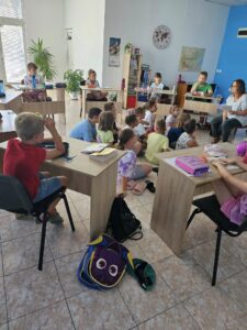 Децата внимателно слушат учител в класната стая в образователен център „Вени Кидс“.